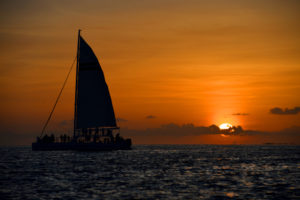Image of a sunset with sail boat in the foreground