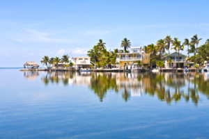 picture of calm water looking towards homes and boats on the water